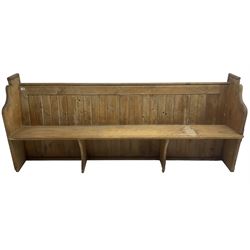 Early 20th century pine church pew, vertical plank back over rectangular seat, flanked by shaped end supports, with bible rest to back