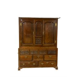18th century oak housekeepers cupboard, two panelled doors above floral carved panels, three short and two long drawers, raised on ogee bracket feet