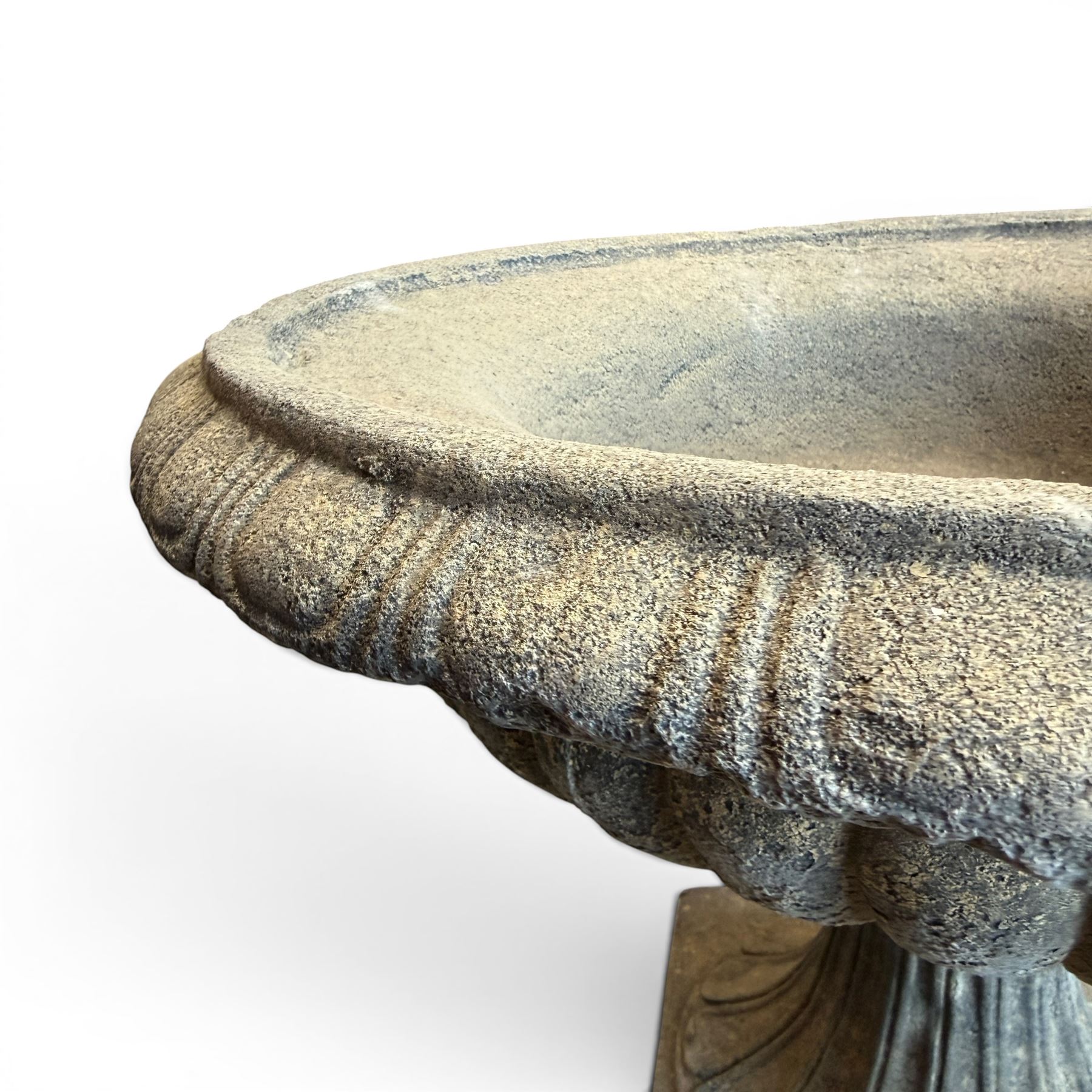 Pair of cast stone garden urns of kylix form on pedestals, the broad egg-and-dart moulded rim over a shallow gadrooned underbelly, with waisted tapering base, raised on matching plinth bases with faux panelled facia