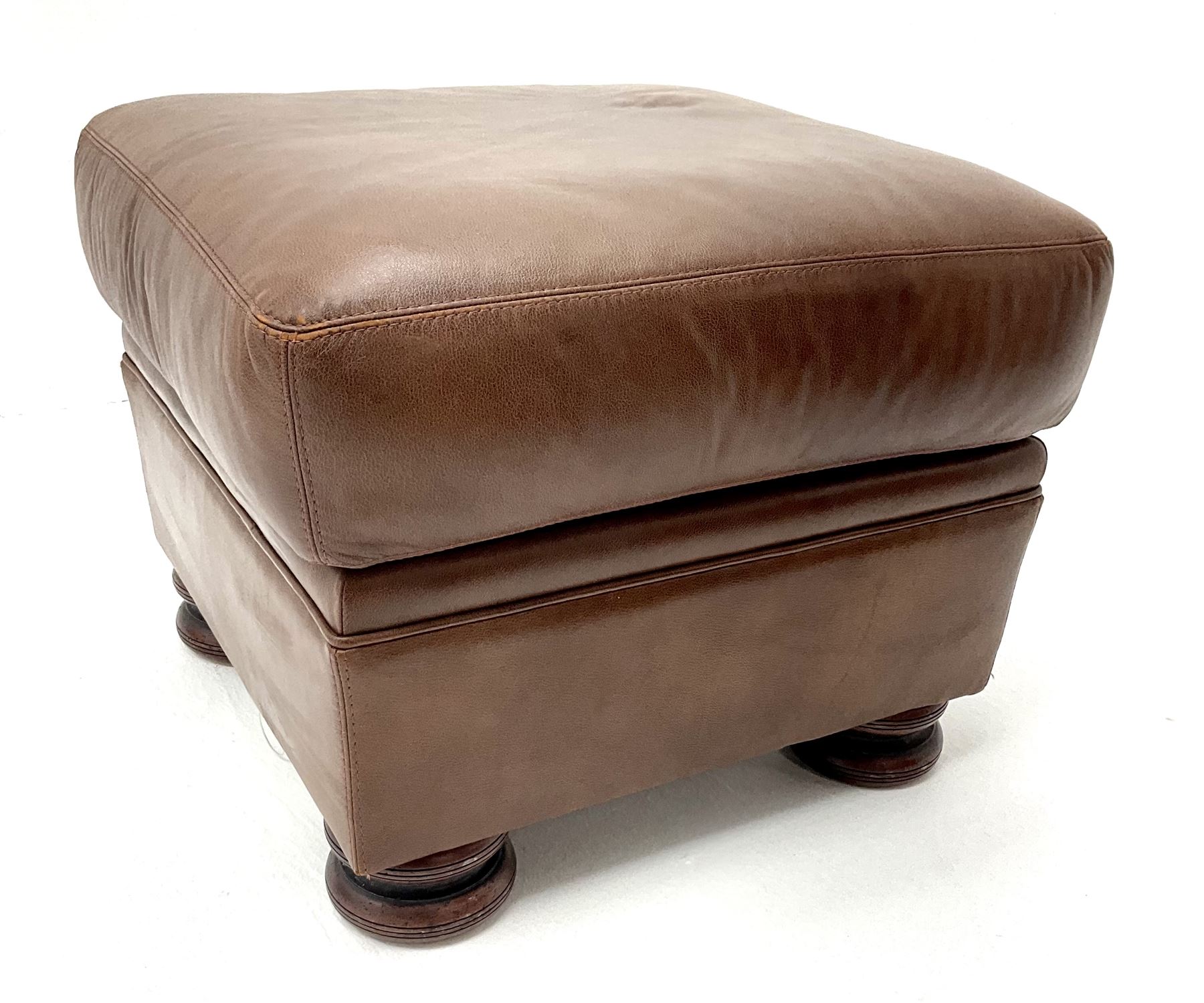 Three seat studded tan leather sofa, scrolling arms, turned supports (W190cm) with matching two seat (W155cm) armchair (W100cm) and footstool 