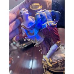 Mid 18th century Meissen figure group, The Tyrolean Dancers, circa 1740, modelled as two swirling figures with their arms linked, he in yellow hat with red rosette, blue jacket, red breeches with red rosette, and yellow shoes with green rosette, she in white blouse with red ribbons, yellow and red bodice, white apron over puce skirt and yellow shoes with green rosettes, her hair fashioned into two plaits secured by red ribbon, upon a shaped mound base, within a scrolling gilt metal mount, with blue crossed swords mark to base, overall H19cm
