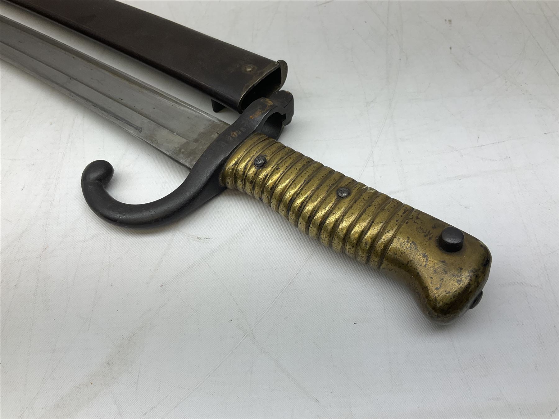 French model 1866 sabre bayonet, the 57.5cm curving blade marked St. Etienne 1868; in associated steel scabbard L71cm overall