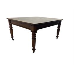 Late 19th century extending mahogany dining table, square top with banded frieze rail, raised on turned octagonal supports with  brass cups and castors, with two additional leaves
