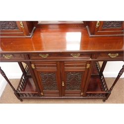  Edwardian walnut side cabinet, the mirrored back with open balustrade over three beveled glass panels and two carved cupboard doors, base with three frieze drawers, over a pair of carved cupboard doors flanked by open mirror back display shelves, W127cm, H179cm, D43cm  