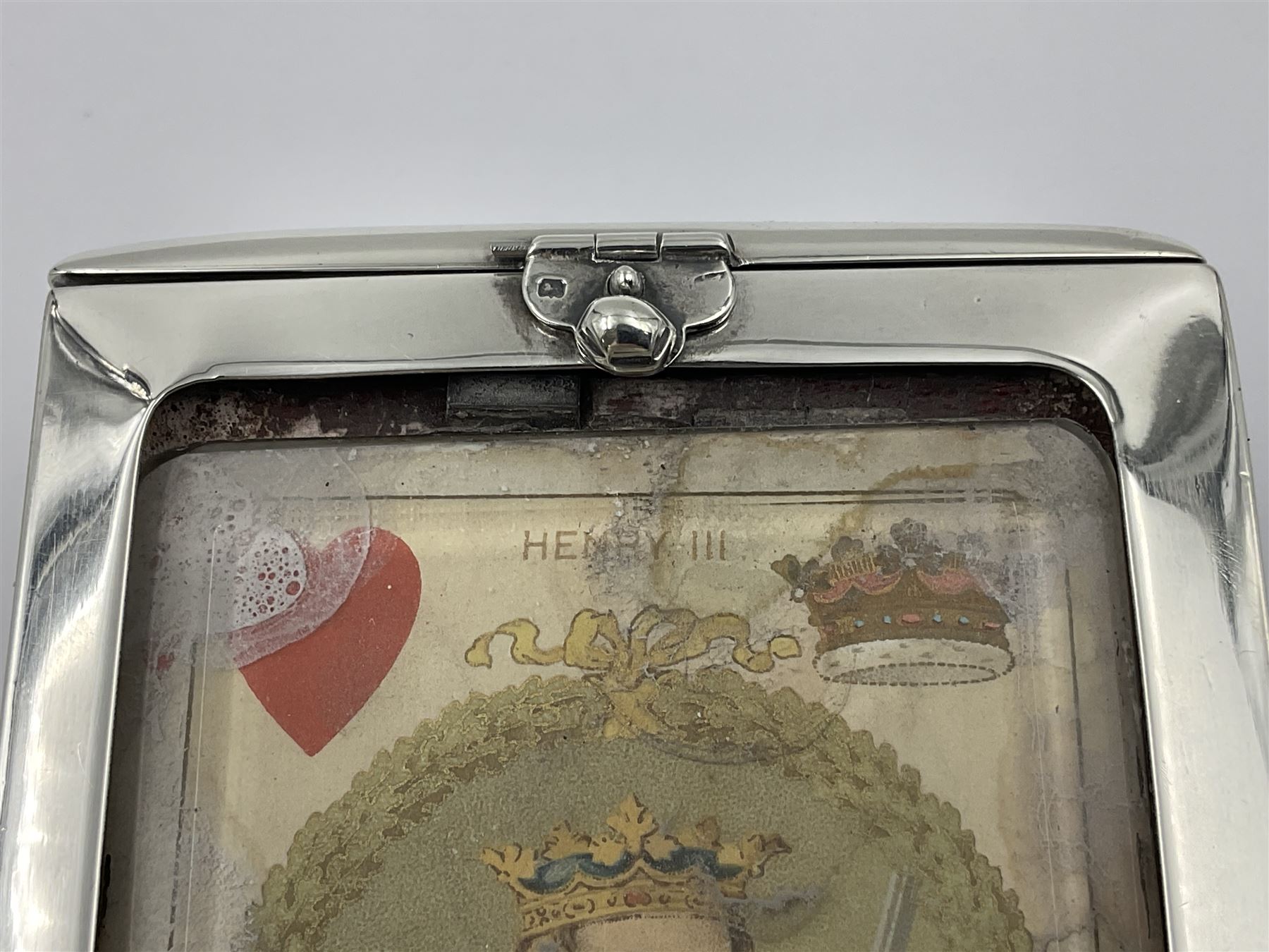 Edwardian silver mounted playing card case, hallmarked William Harrison Walter, Birmingham 1903, the sides each with a period playing card set behind a bevelled glass panel, the hinged cover with later engraving 'Presented to Norman T Crombie Esq by the officers & men of the 31st WR Detachment for services rendered 1917-1918', with red leather lined interior, the three compartments upon a sprung base and containing two later wooden Whist markers, case H12.5cm