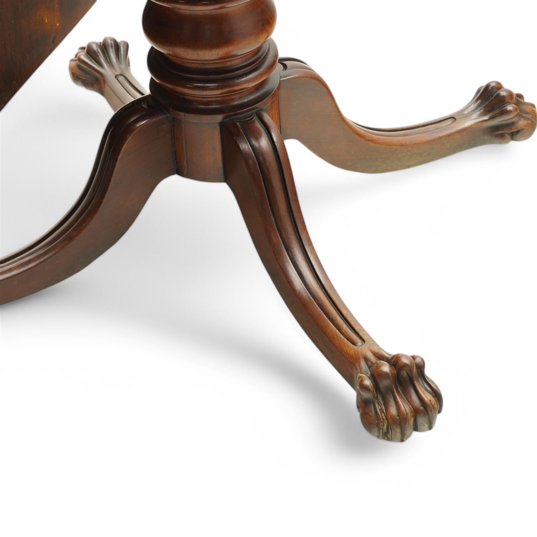 Large Regency mahogany breakfast table, figured rectangular tilt-top with rounded corners, on wide turned pedestal with four out-splayed moulded supports, paw carved terminals with recessed castors 