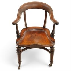 19th century carved mahogany Captain's desk chair, the bow-shaped cresting rail over curved back and turned arm supports, shaped saddle seat raised on turned supports united by crinoline stretcher, with brass cups and ceramic castors
