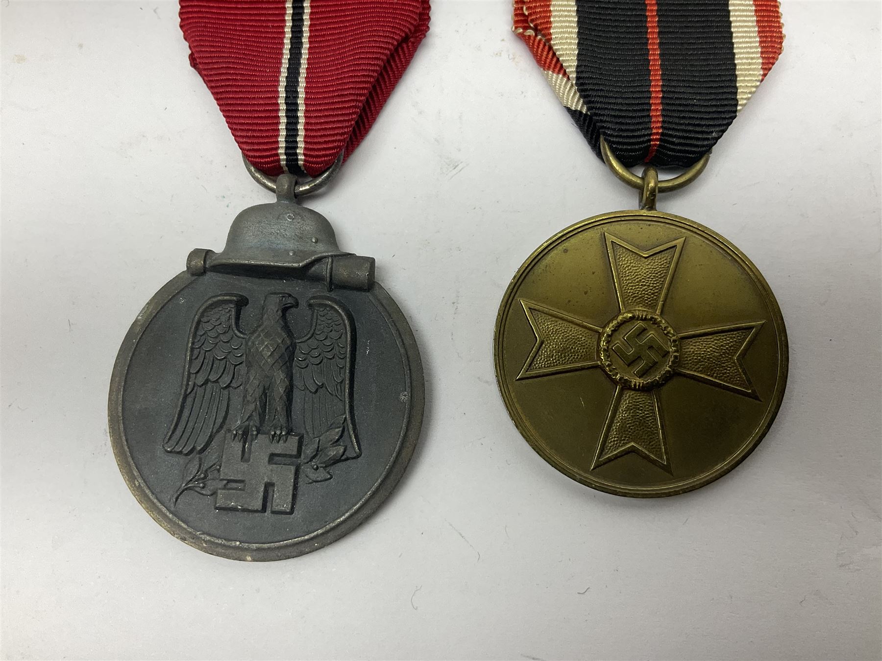 German War Merit Cross 1st Class, the pin-back stamped '50'; War Merit Medal; and Ostfront Medal for the Winter Campaign in Russia of 1941-1942 'Die Medaille Winterschlacht Im Osten'; all with ribbons (3)