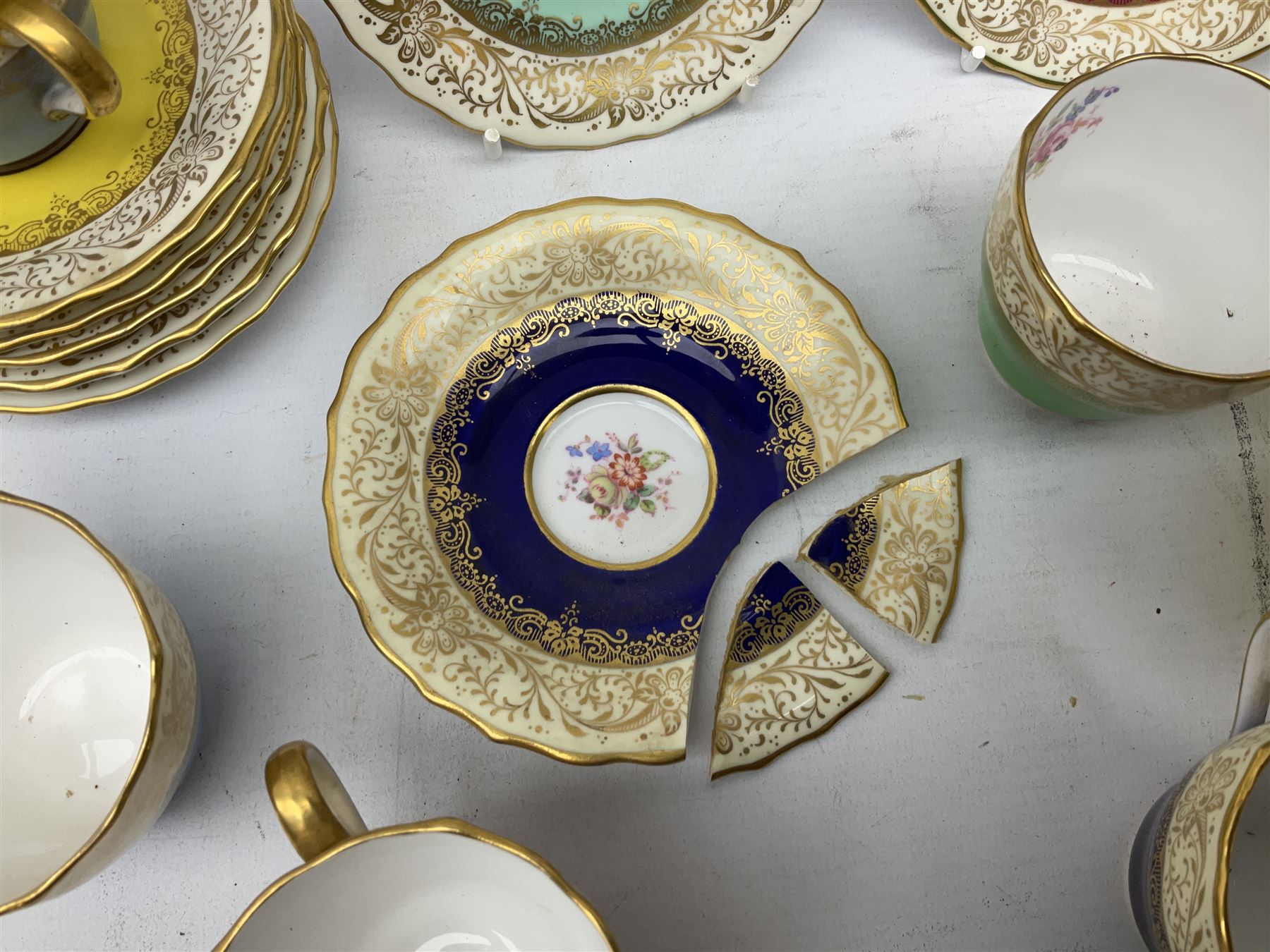 Twelve Spode Ruskin pattern coffee cups and saucers, with floral bouquets, varying colour grounds and gilt