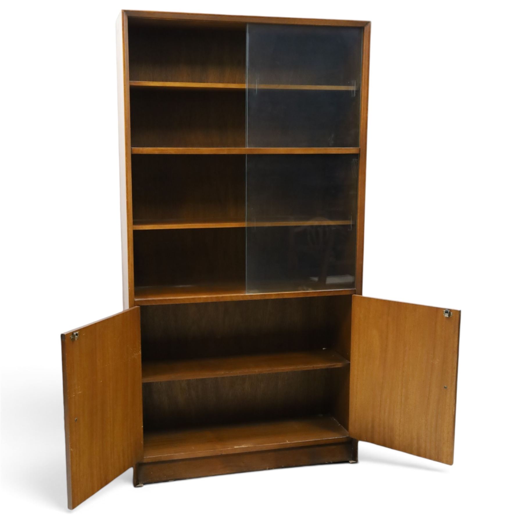 Herbert E Gibbs - Mid 20th century teak glazed bookcase cabinet, rectangular form with two sliding glazed doors enclosing adjustable shelves, lower cupboard enclosed by twin doors and fitted with internal shelf, on plinth base