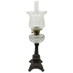 Victorian cast spelter oil lamp, the quatrefoil base on four paw feet leading to a square plinth and column decorated with putti, masks, and foliate scrolls, supporting a faceted clear glass reservoir, burner, clear glass chimney, and foliate etched clear glass shade, overall H68cm  