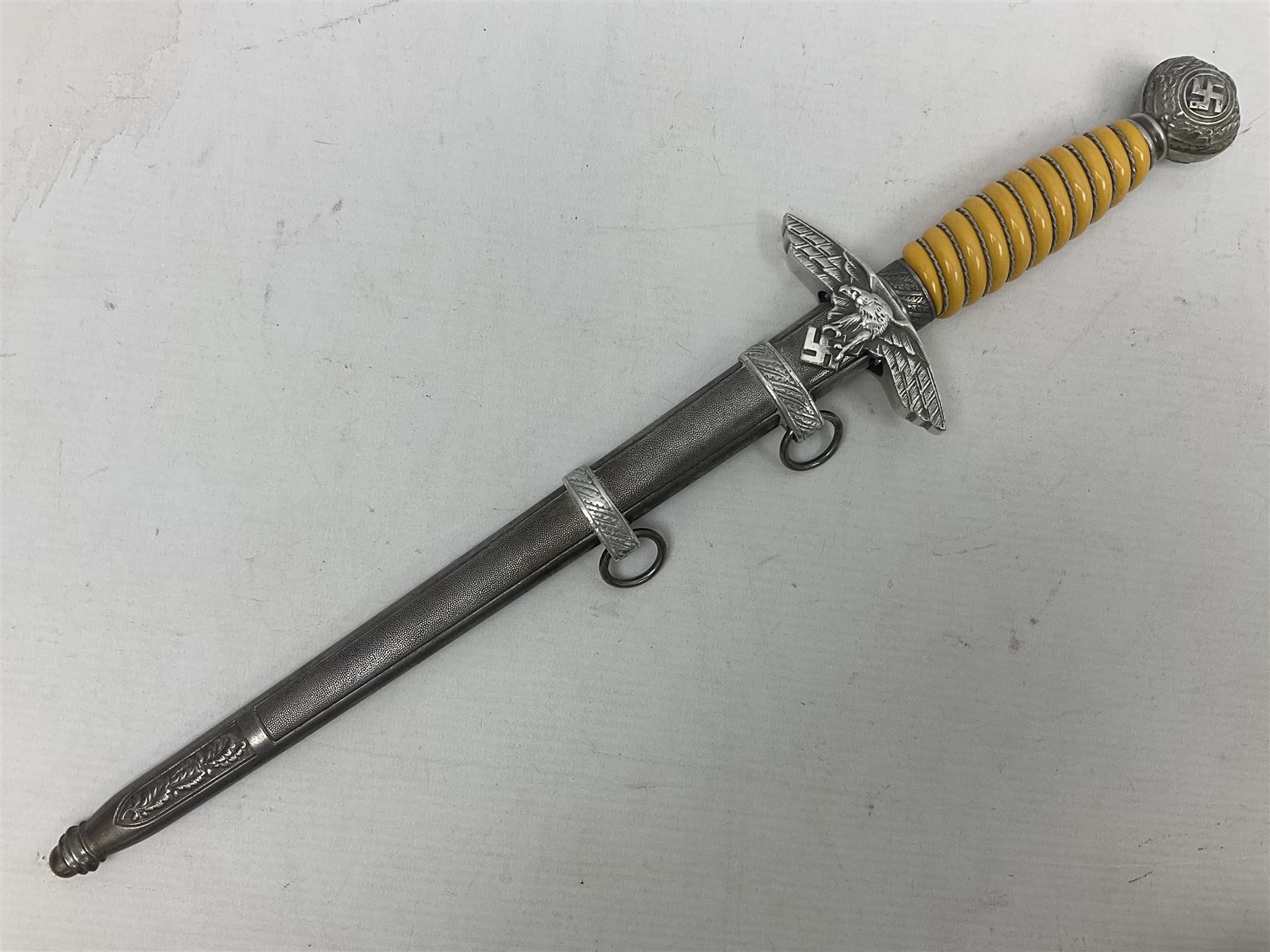 WW2 German Luftwaffe 2nd Pattern Officers dress dagger, with unmarked 25.5cm double edged steel blade, wire-bound pale orange/yellow celluloid grip, globular  pommel with oak leaves and traces of gilding, Luftwaffe eagle cross guard; in beaded scabbard with two suspension rings L43cm overall