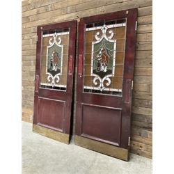 Two early to mid 20th century timber doors, set with lead framed stained glass panels depicting agricultural worker and horse