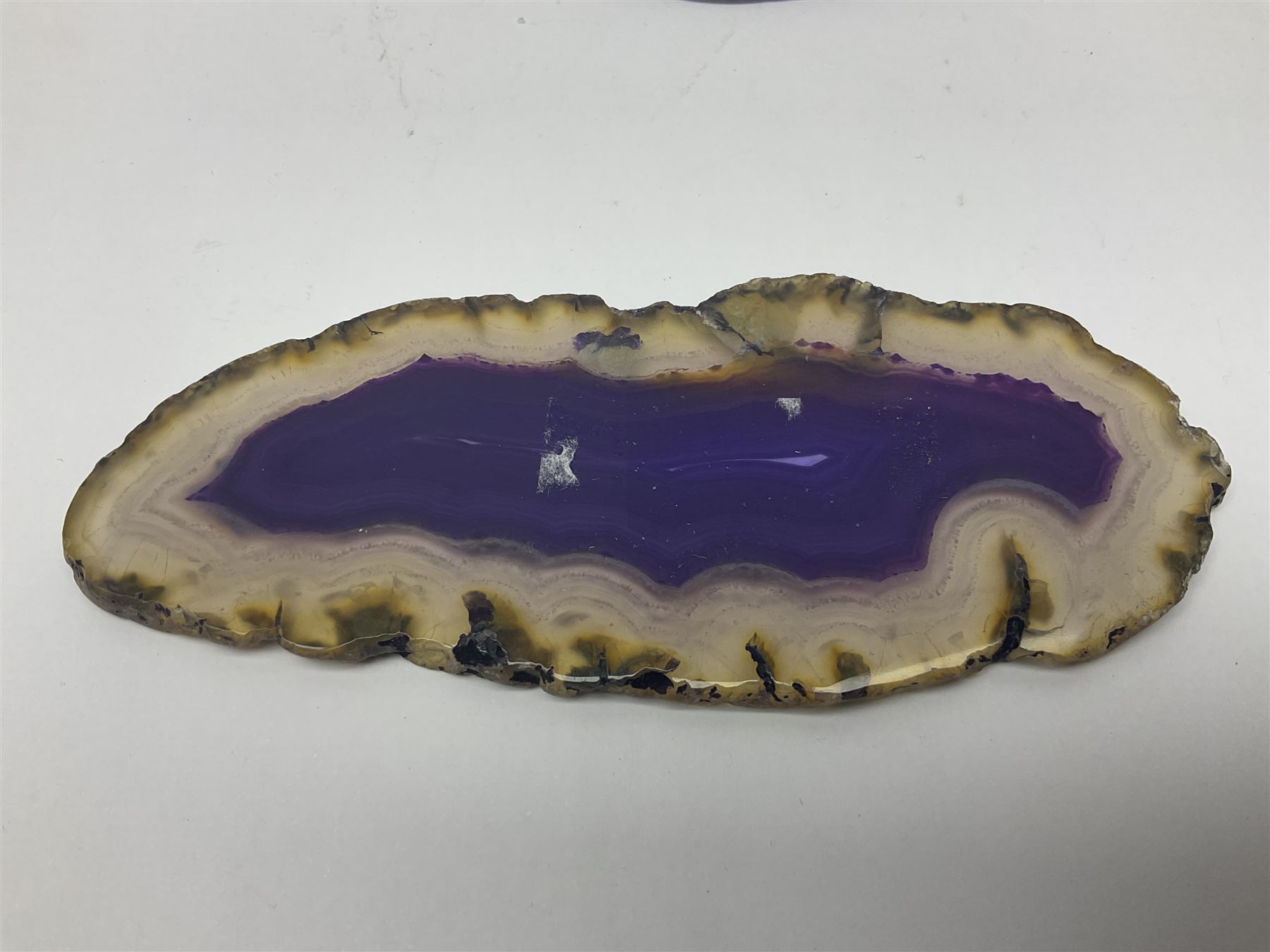 Four purple agate slices of various sizes, polished with rough edges