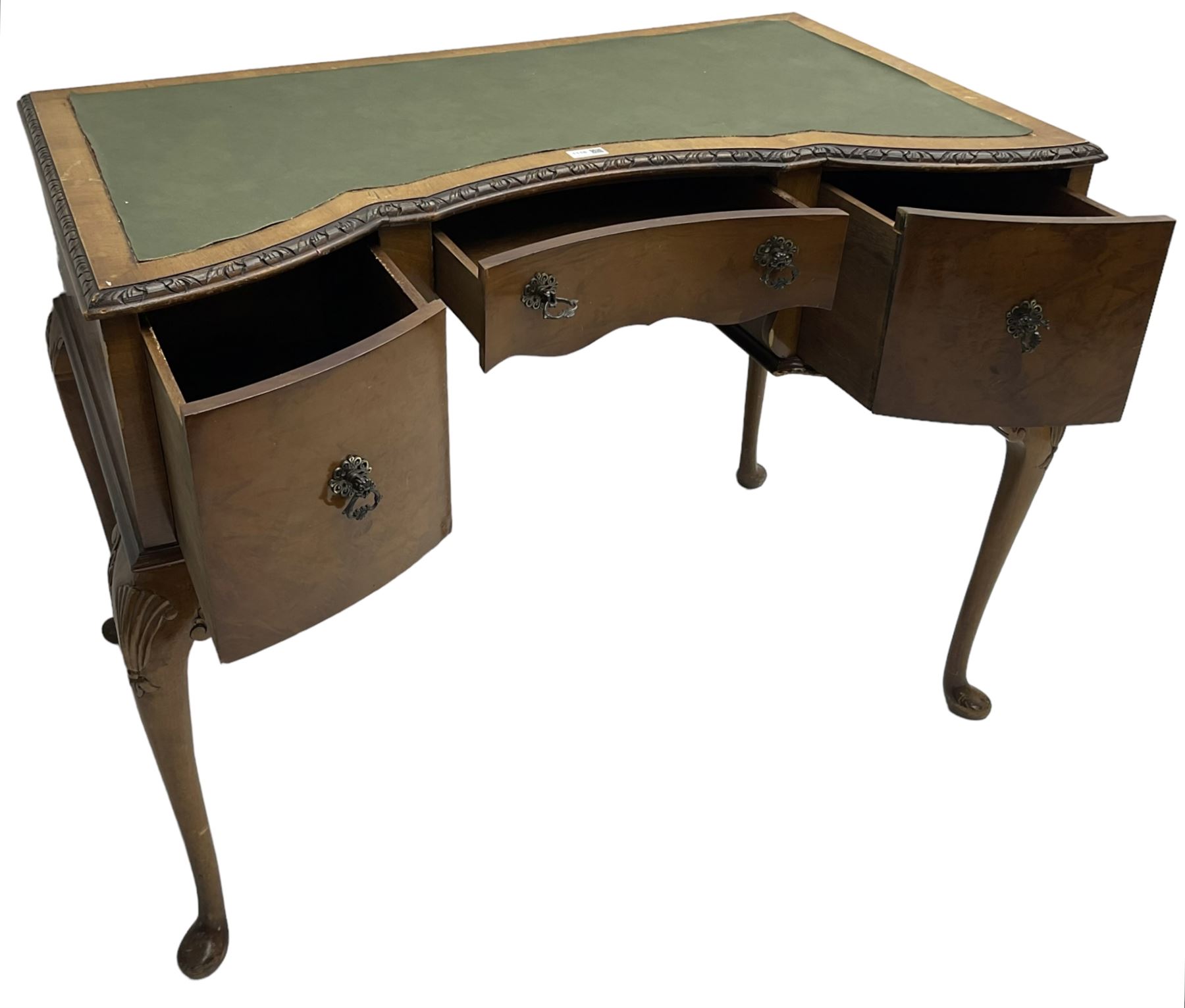 Early 20th century Queen Anne design walnut writing desk, reverse bow-front with inset green leather writing surface and foliate carved edge, fitted with three drawers, raised on cabriole supports