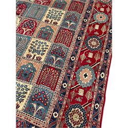 Persian Bakhtiari crimson ground carpet, the field divided into seventy panels decorated tree of life motifs, mihrabs and stylised plants, the border decorated with repeating circular medallions formed of Hac motifs, floral pattern guard stripes 