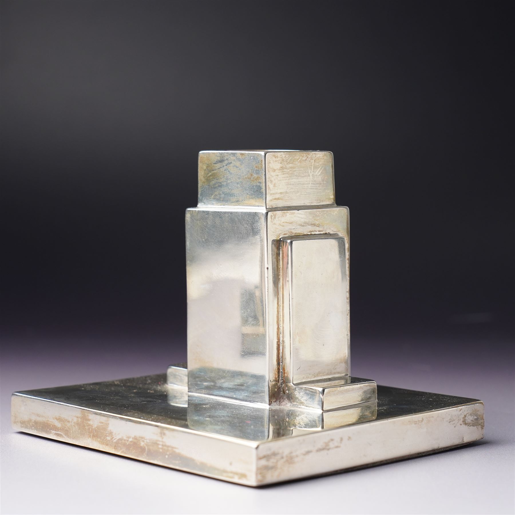 Pair of Art Deco silver candlesticks with square section stems supported by two lappets on a rectangular base H7.5cm x W9.5cm Sheffield 1935 Maker Walker & Hall