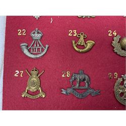 Eighteen glengarry and cap badges including Argyll & Sutherland, Black Watch, Kings Own Scottish Borderers, Royal Scots, Royal Tank Corps, Royal Armoured Corps, Royal Marines, East Lancashire, Hampshire Yeomanry Carabiniers etc; mounted on a board for display