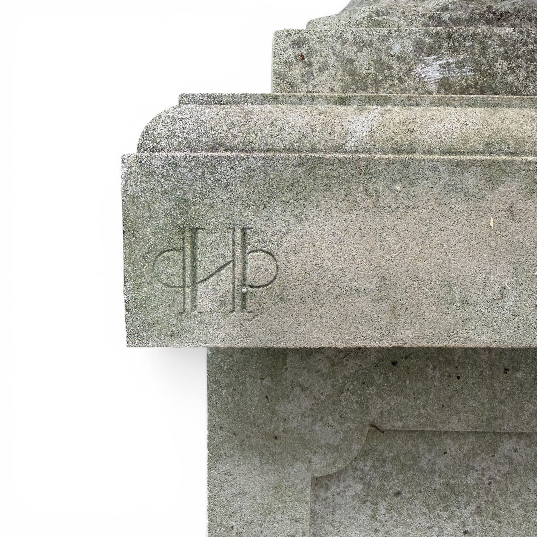 Pair of weathered cast stone Neoclassical design garden Kylix shape urns, foliate moulded rim over a gadrooned underbelly, the scalloped socle over a rectangular pedestal with faux-panelled sides, stamped with stylised ‘H’ monogram