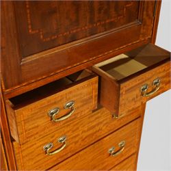 Edwardian mahogany triple combination wardrobe, the moulded cornice above a central panel door inlaid with foliate detail, flanked by full length mirrored doors, the interior fitted with hanging compartments and a central bank of two short and three long drawers, raised on a shaped bracket feet