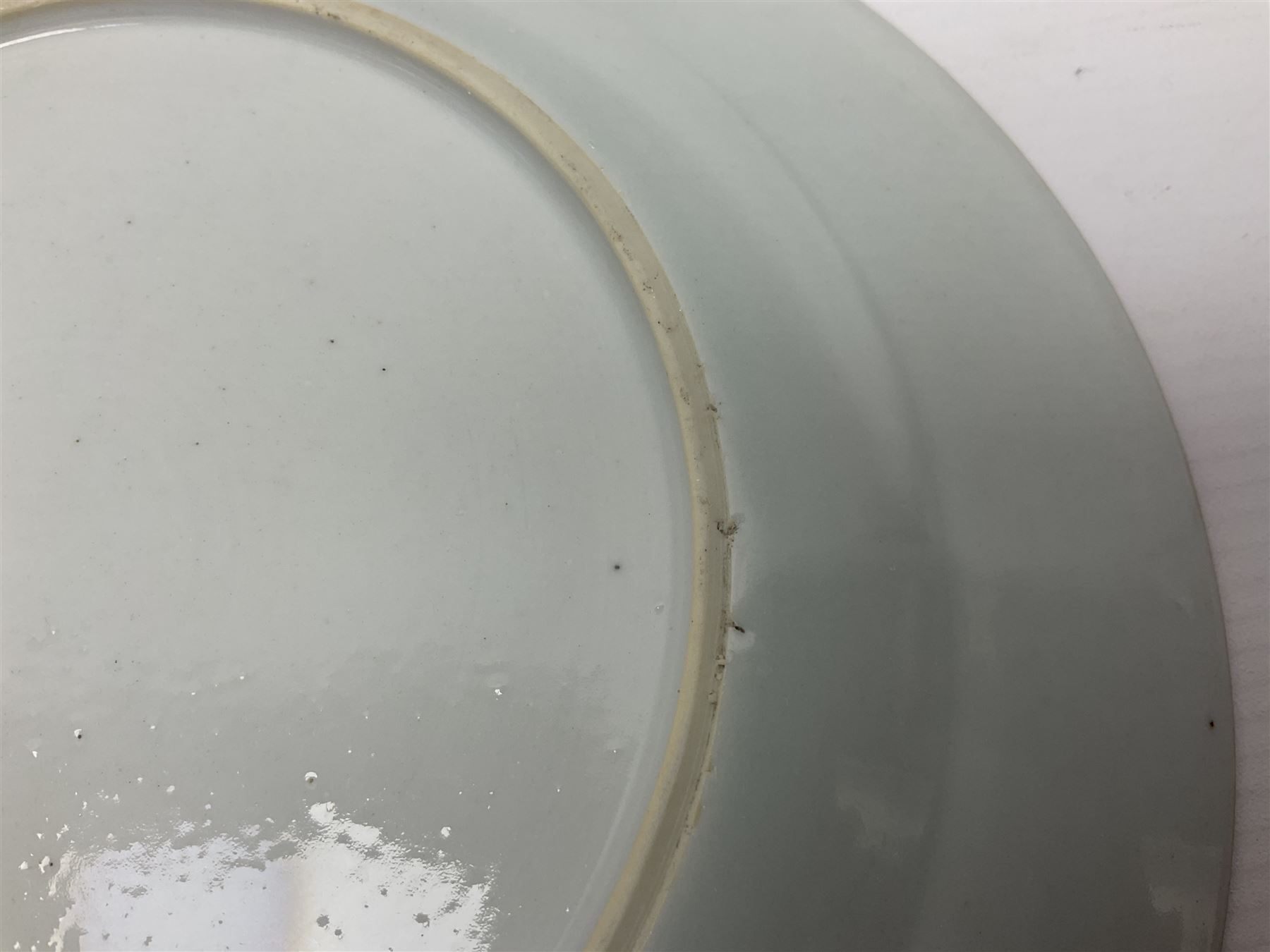 Three 18th century Chinese Famille Rose plates, the first example enamelled with blossoming peonies, rockwork and fence, the other two examples of similar design, decorated with blossoming peonies and sprigs within shaped inner borders, each approximately D23cm