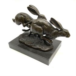 A bronze figure group, modelled as two hares in chase, signed Nick and with foundry mark, upon a rectangular marble base, overall H11cm L13cm
