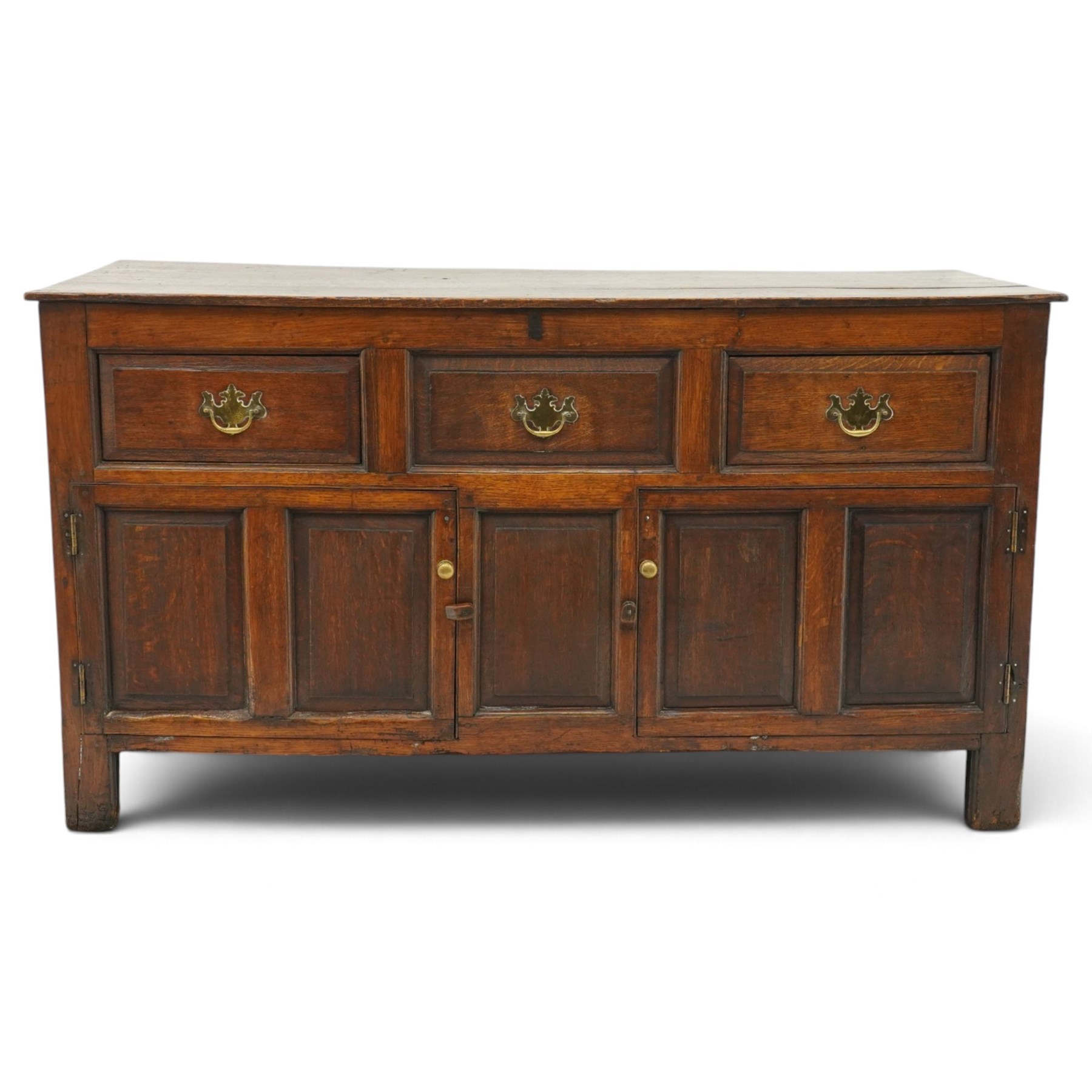 18th century oak dresser base, rectangular top over three drawers, fitted with twin panelled hutch-cupboard doors flanking central fielded panel, raised on stile supports