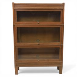 Globe Wernicke - Modular oak sectional bookcase, the three glazed up-and-over doors with panelled sides, raised on a plinth base with square supports