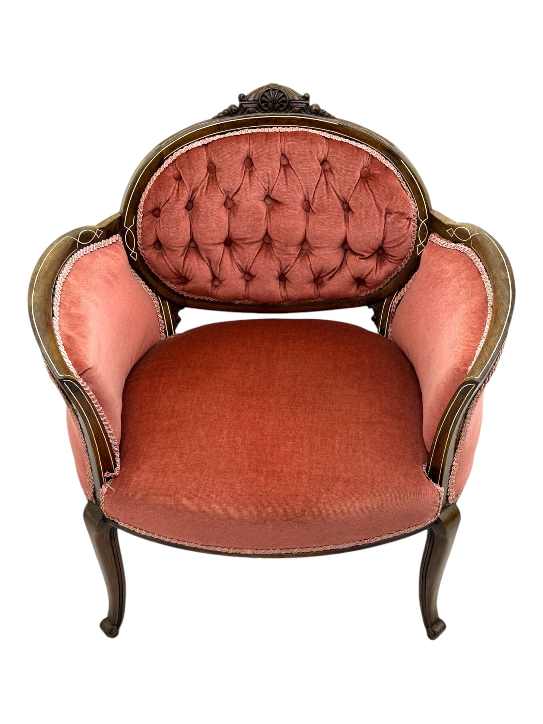 Edwardian inlaid rosewood parlour suite, comprising pair of tub shaped armchairs (W77cm, D69cm, H88cm); and matching two-seat sofa (W112cm, D69cm, H88cm), each with carved crest rails with shell motifs, deep button-tufted oval backs upholstered in pink fabric with braid trim, on cabriole supports