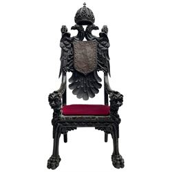 Grand mid-to-late 19th century heavily carved beech framed throne chair, the crown pediment carved with flower heads and cross finial, scroll and acanthus carved upright supports with twin perching griffin back enclosing etched leather work heraldic shield with castle and lion motifs over splayed feathers, flower head carved down sweeping arms with grotesque carved terminals, the seat rails carved with further flower heads on moulded supports with oversized ball and claw carved feet

Provenance: A very similar chair was used in the filming of Stanley Kubrick's 'Eyes Wide Shut' (1999)
