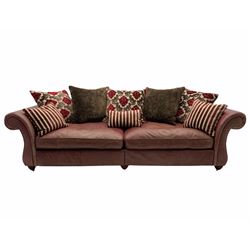 Grande traditional design three seat sofa, upholstered in salmon pink leather with contrasting scatter cushions, brass castors (in two sections)
