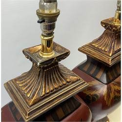 Pair Oriental table lamps decorated with birds in a tree with fruit, on a red ground with a gilded base together with cream lampshades H57cm, without lampshade. 