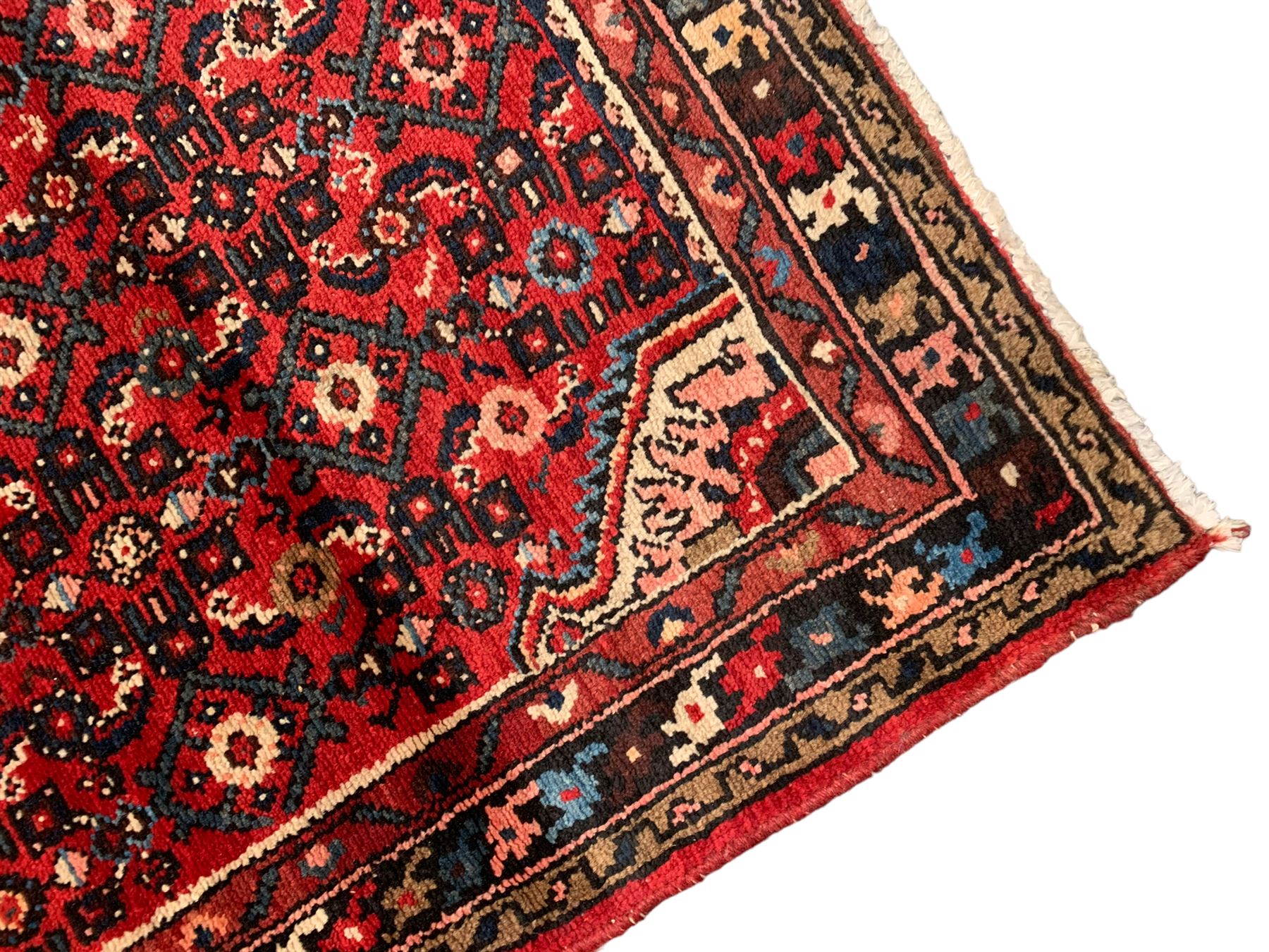 Persian crimson ground runner, the field decorated with Herati motifs,  three-band border, the main band decorated with repeating flowerheads 