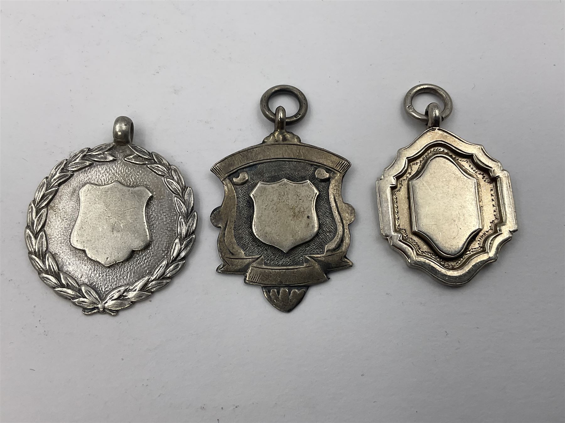 Ten early 20th century silver cartouche fobs, to include a Yorkshire Rose example, all hallmarked with various dates and makers

