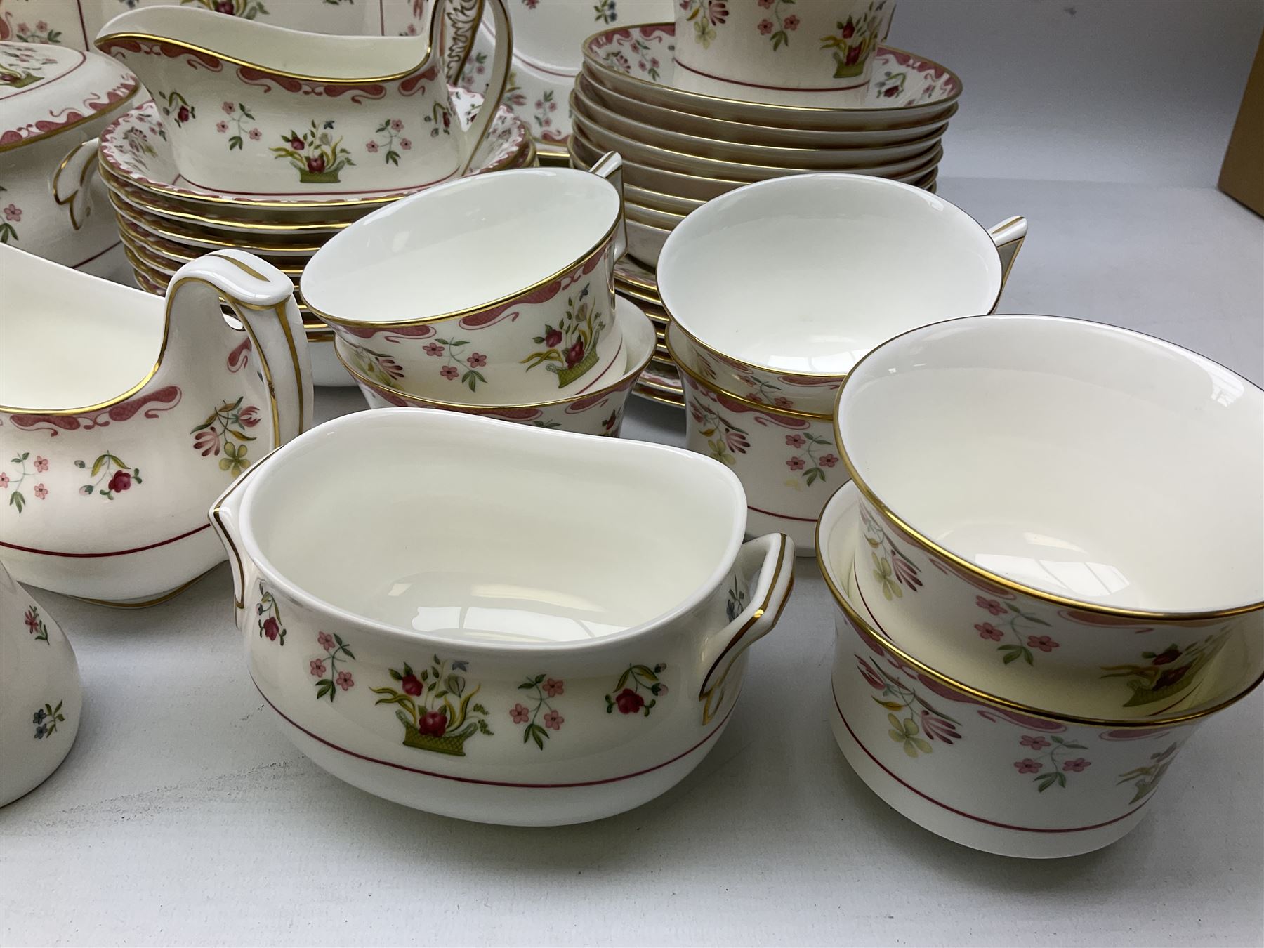 Wedgwood dinner service decorated in the 'Bianca' pattern, to include eight dinner plates, eight bowls, eight side plates, eight twin handled souo bowls, eight soup bowl saucers, eight teacups, eight teacup saucers, six dessert plates and two larger, two twin handled lidded tureens, milk jug, two sauce boats, salt and pepper shakers, oval serving  plate, twin handled sandwich plate, covered sucrier, small rectangular dish and two small circular dishes, all with printed stamp mark beneath