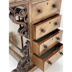 Victorian walnut Davenport, raised pen and ink compartment over sloped hinged top with inset writing surface, birds eye maple interior fitted with small drawers and pigeon holes, right-hand side fitted with four drawers, left-hand side with four false drawers, pierced and scroll carved brackets, on sledge supports with turned bun feet with recessed castors