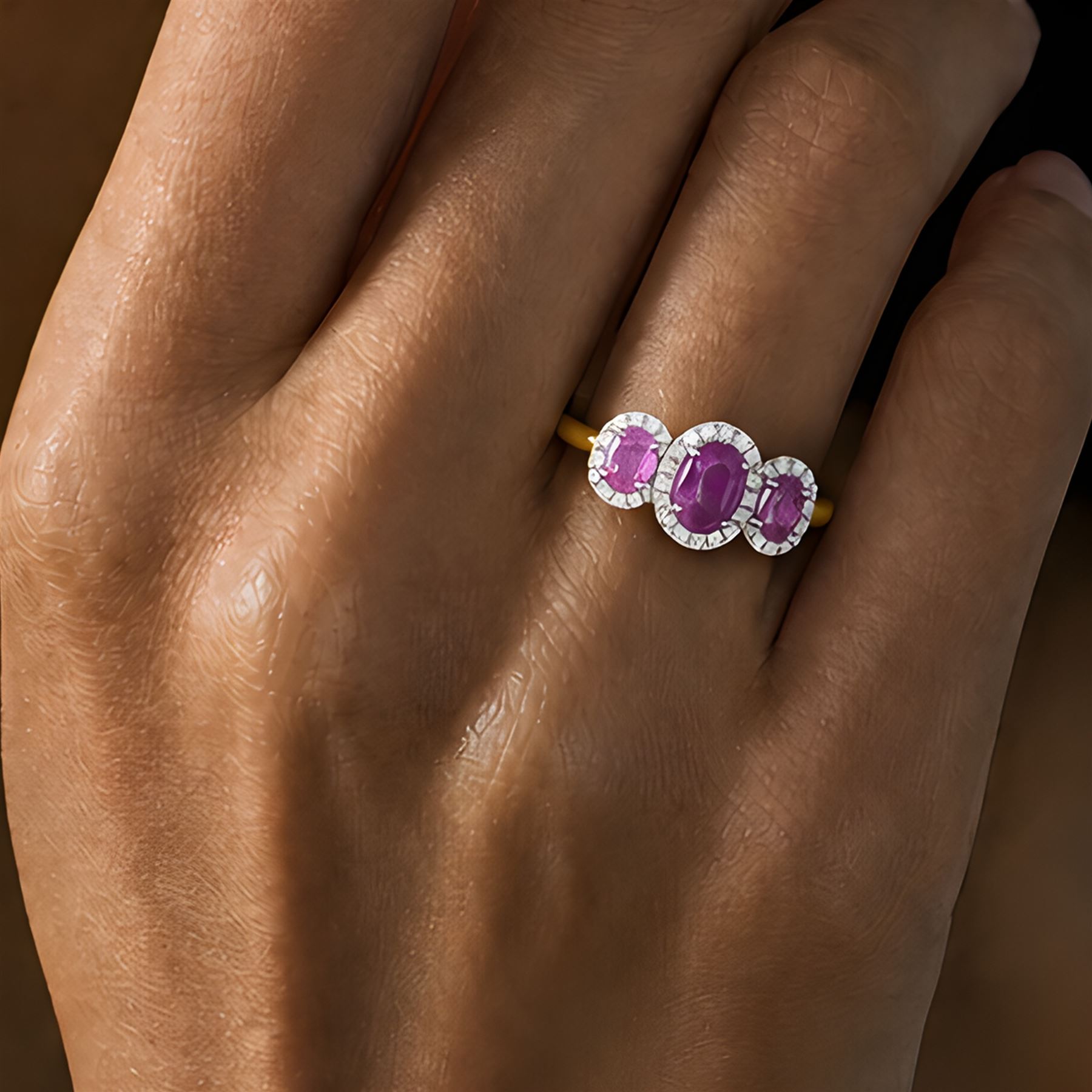 18ct gold pink sapphire and diamond trilogy ring, three oval cut sapphires surrounded by round brilliant cut diamonds, hallmarked, total sapphire weight approx 1.45 carat, total diamond weight approx 0.25 carat