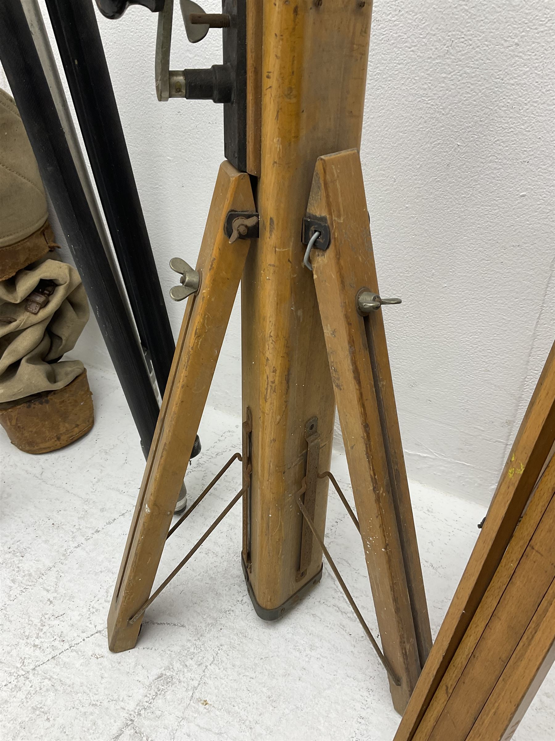 Three wooden adjustable tripods for plate cameras, together with a Linhof of Munchen metal tripod in a canvas case 
