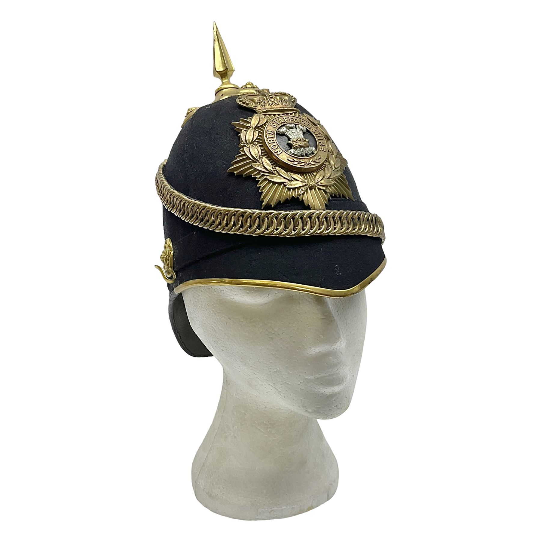 Late Victorian North Staffordshire Regiment Officer's Home Service Blue Cloth Helmet, having incorrect other ranks gilt metal Queen's crown helmet plate to the front with later leather backing, removable spike to the top on a shaped cruciform base with rosette fittings, rosette side bosses, brass trim to the front peak, and leather and velvet backed chin scales, with leather sweat band, the interior with makers stamp for Hawkes & Co 14 Piccadilly London