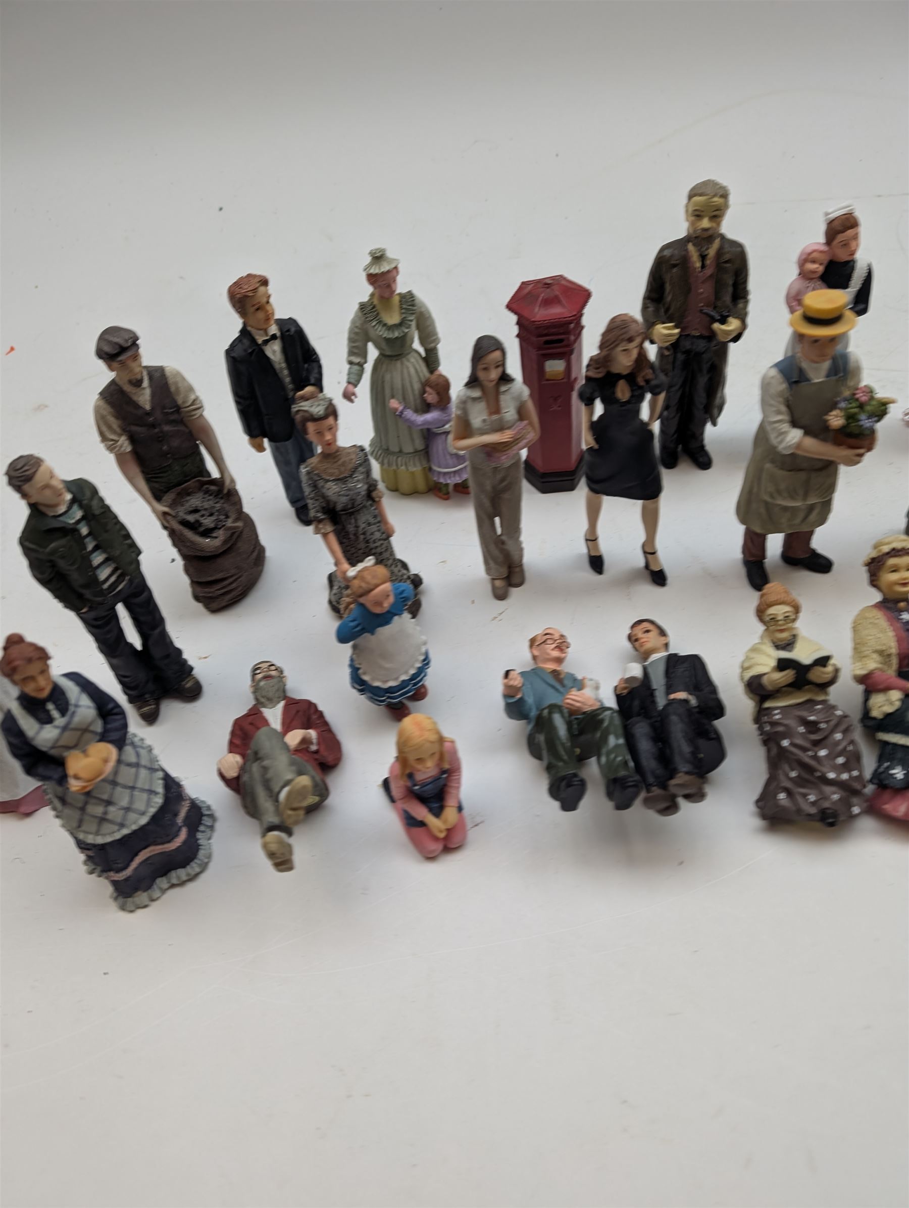 1:12 scale dolls house composite figures, including policeman, postman, maid, sitting and standing people in various styles of dress, etc