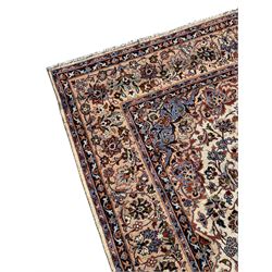 Persian Najafabad ivory and peach ground rug, central rosette medallion surrounded by swirling leafy branches and palmettes, trailing border decorated with stylised plant motifs, enclosed within floral pattern guard stripes