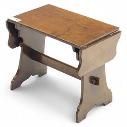 Early 20th century oak drop leaf cottage table, rectangular top with twin hinged leaves, on shaped trestle end supports united by central stretcher