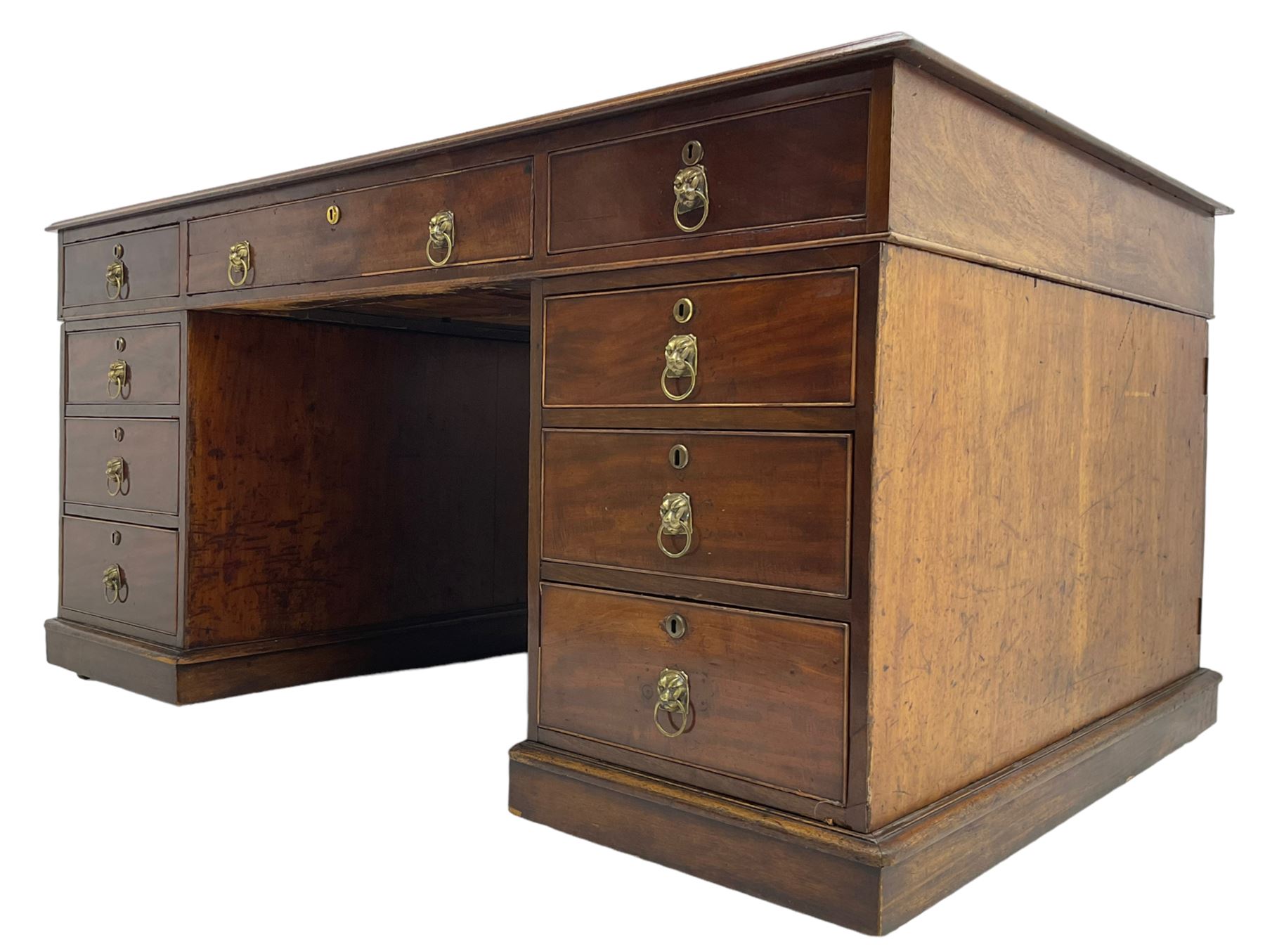 George III mahogany twin pedestal partners desk, rectangular top with moulded edge and an inset green tooled leather writing surface with Greek key design border, fitted with three cock-beaded frieze drawers to each side, each pedestal with three graduating drawers with an opposing panelled cupboard enclosing a single shelf, the facias fitted with brass lion mask plates with ring handles, the lower moulded edge over a plinth base and castors, London furniture dealers label to interior of drawer inscribed 'J. Webb, Office Furniture 323, Gray's Inn Road, King's Cross'  H75cm  W153cm  D97cm