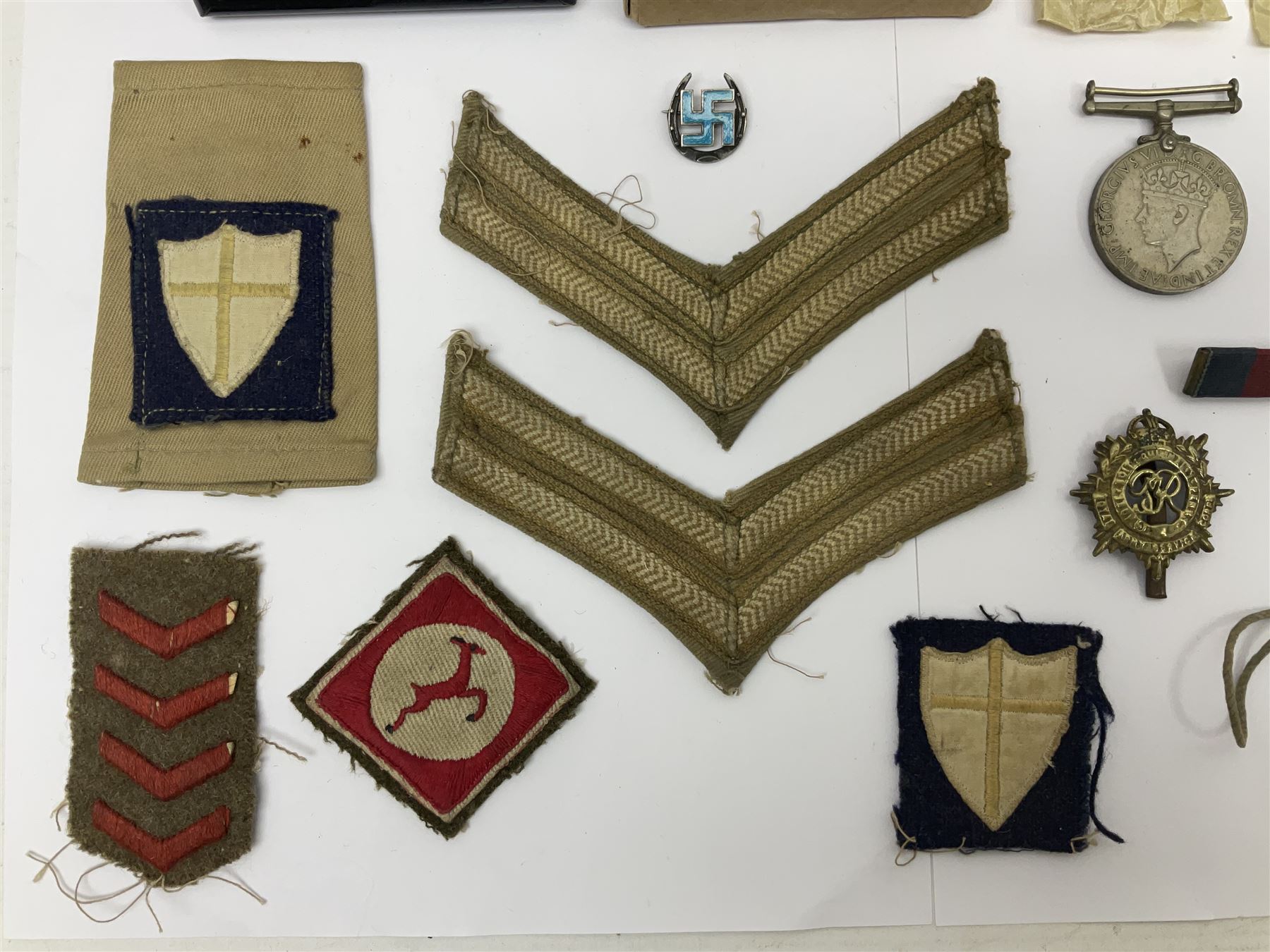 WWII group of three medals comprising 1939-45 War Medal and Italy and Africa Stars in issue box; dog tags for 282894 W. Wilkinson with framed photograph in uniform; and small quantity of cloth and metal badges including RAOC cap badge