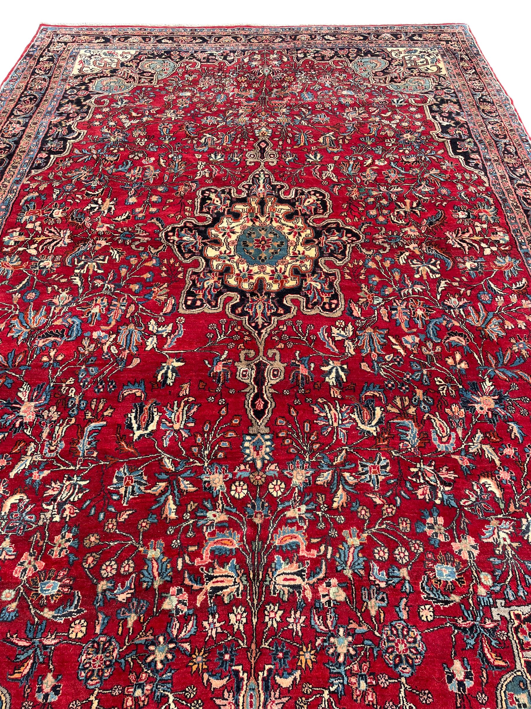 North West Persian Bidjar red ground carpet, shaped pole medallion surrounded by interlacing branches and stylised flower heads, five band border with repeating floral design