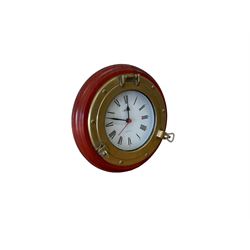 20th century marine clock with a mahogany surround and cast brass “porthole” bezel, with a 6” dial and Swiss battery operated quartz movement.