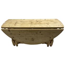 Traditional stripped pine dining table, circular drop-leaf top over double gate-leg action base with turned supports united by turned stretchers