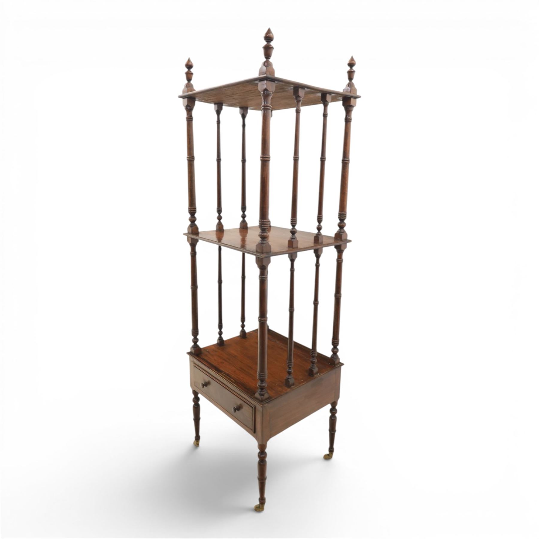 Late Victorian mahogany whatnot, the three tiers supported by turned spindle uprights with turned finials, fitted with a single frieze drawer, raised on turned supports with brass castors