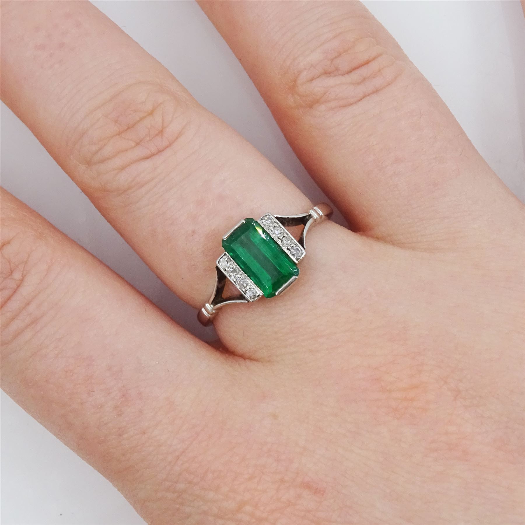 Early 20th century platinum emerald cut emerald and eight stone single cut diamond ring, stamped PT, emerald approx 0.70 carat