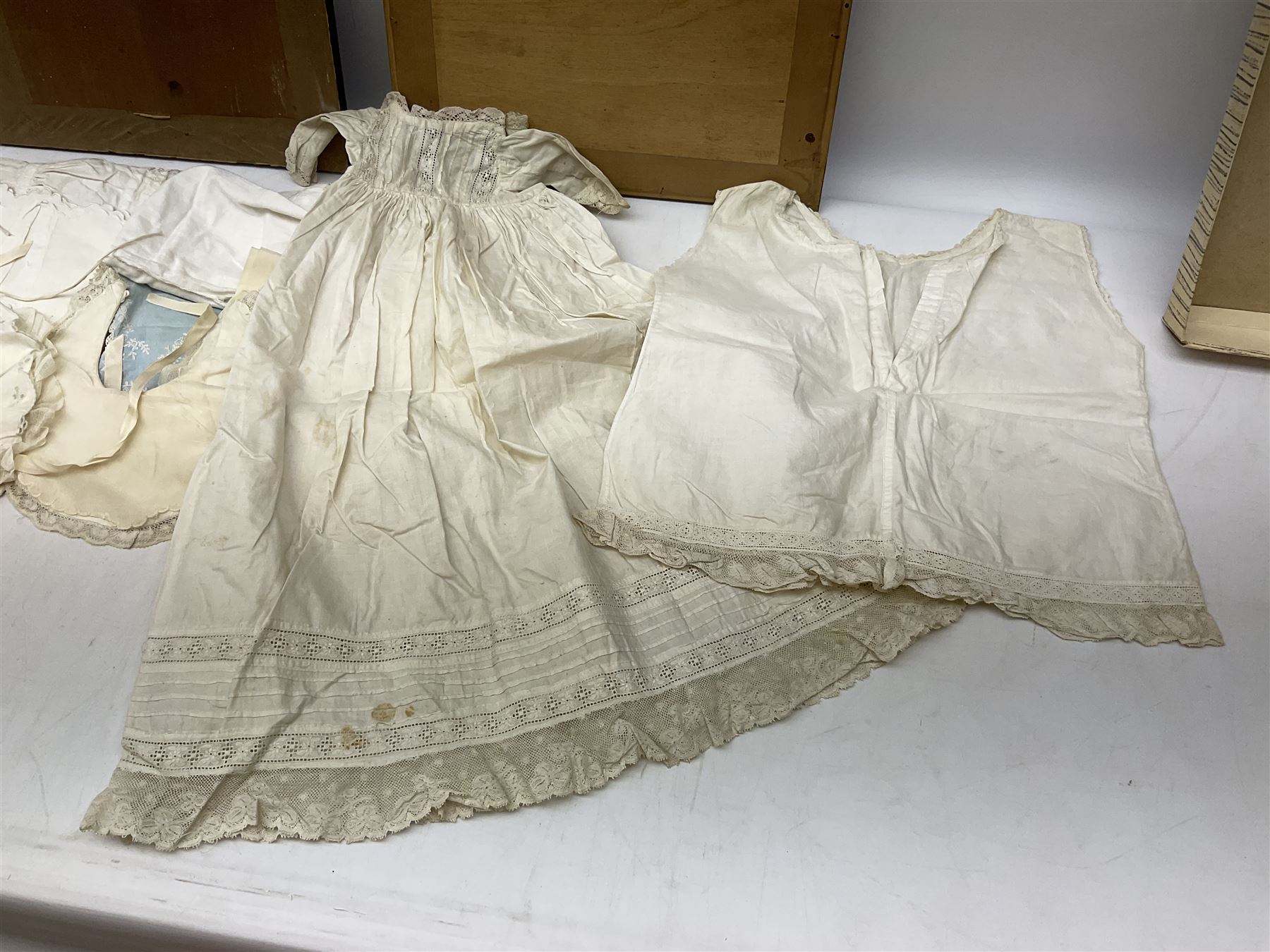 Late 18th century sampler worked with the alphabet above verses in red, by Mary Birkett aged 10 November 16th 1792, H33.5cm W34.5cm, together with another sampler worked with the alphabet above Proverbs 14:23, by Mary Anne Hainworth, Chesham, date unknown (--83), both in glazed frames, together with a quantity of Victorian and later dolls clothes to include lace examples